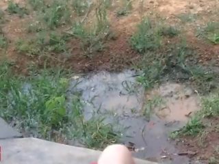 A little 18 years old damsel plays with a hose outdoors in publik